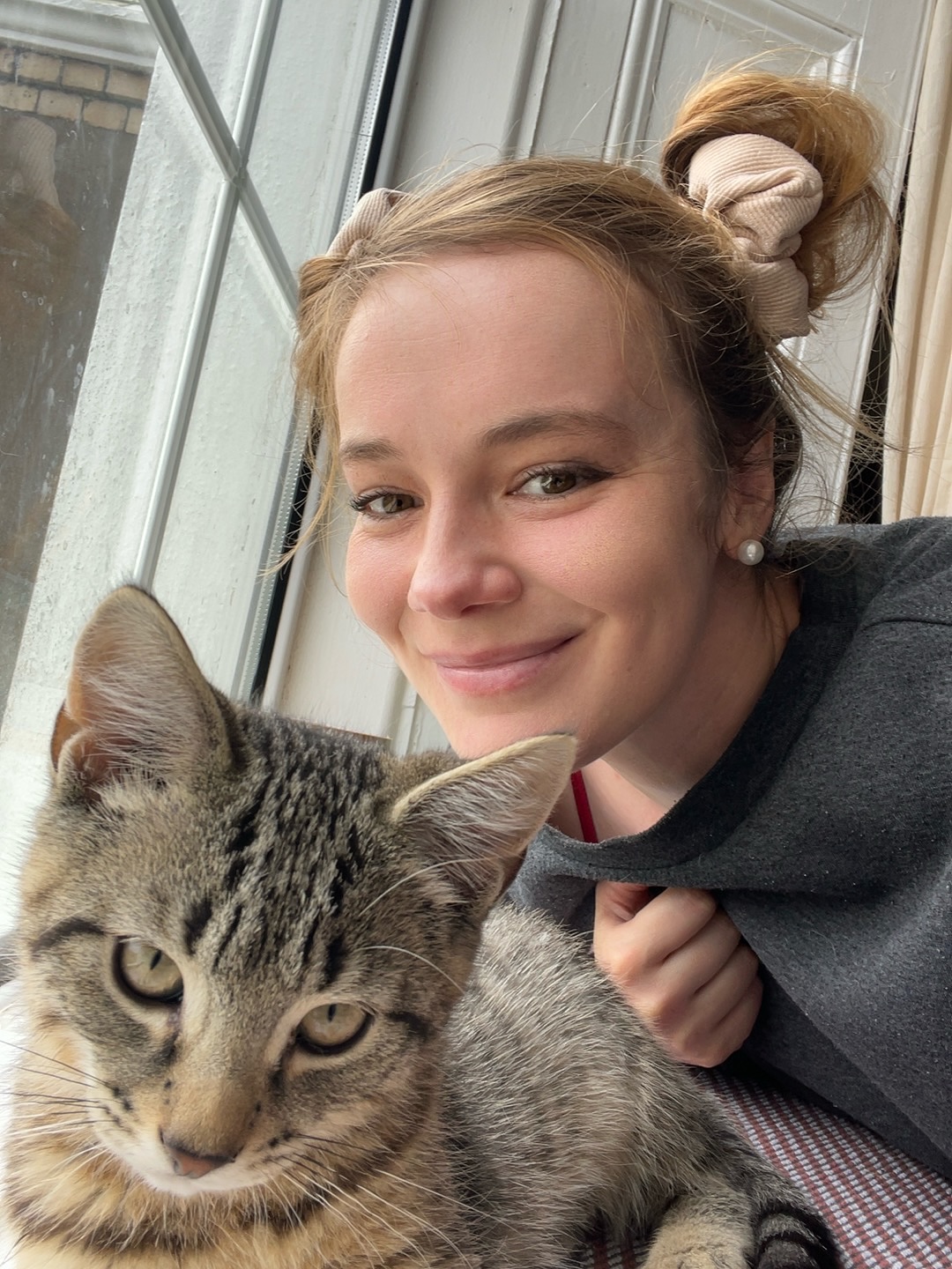 Me by the window with one of my tabby cats.