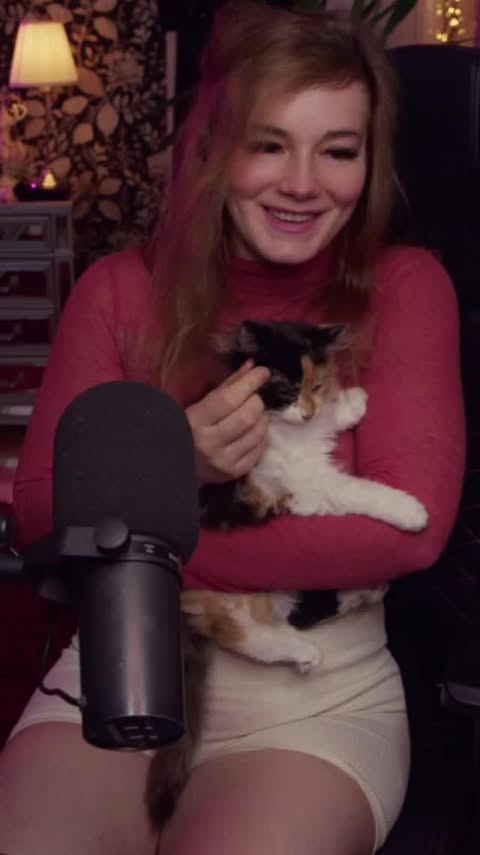 Nou holding a small black-and-white rescue kitten during a stream.